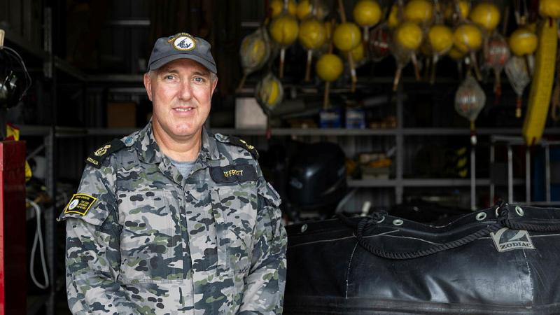 A sailor stands in a warehouse.