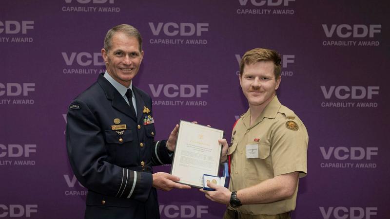 Two men holding up a certificate between them.