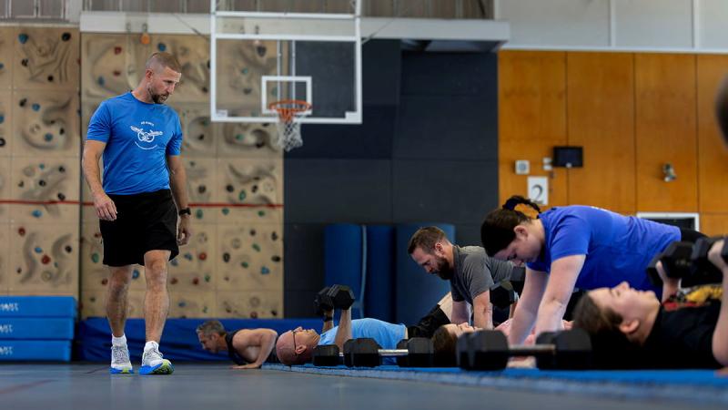 An instructor watches over a group fitness session.