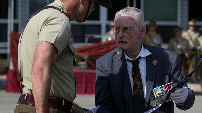 A soldier and an old man engage in discussion.