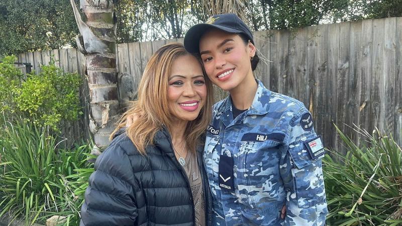 Two women, one in a puffer jacket and the other in Air Force uniform, stand closely together.