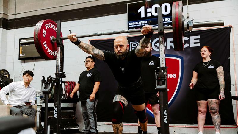 A man prepares to lift a weighted bar.