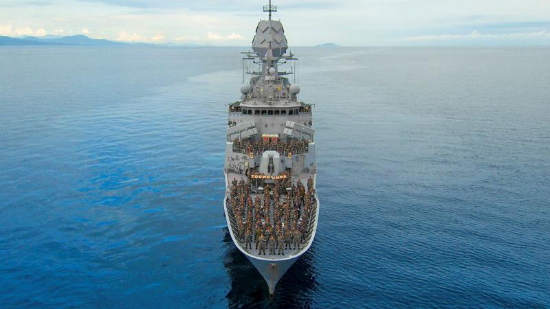 The crew of a ship pose for a group photo on the deck.