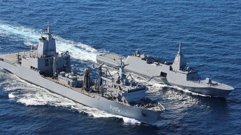 Two ships sail together at sea.