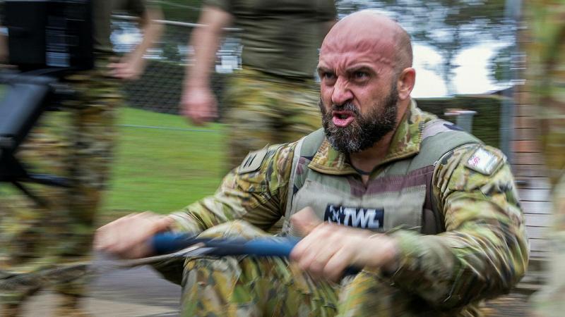 A military member uses a rowing machine.