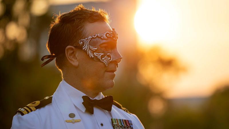 A man wears a mask during sunset.
