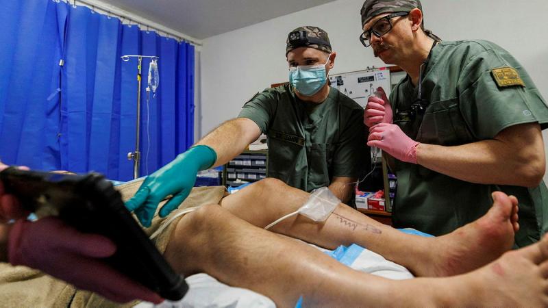 Australian Army Anaesthetist  Major Ashley St John (left) and Major Joseph Dawson (right) administers a peripheral nerve block ahead of performing minor surgery on a member of Operation Render Safe 26, at the Role 2 in Kokopo, Papua New Guinea.