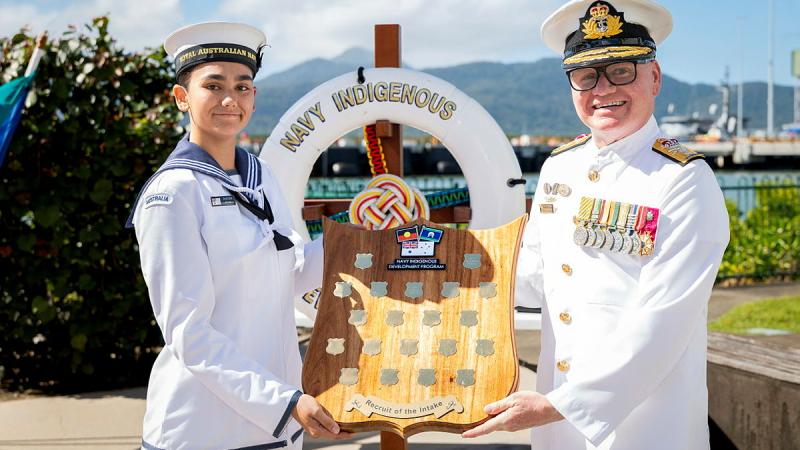 Two people hold a plaque. 