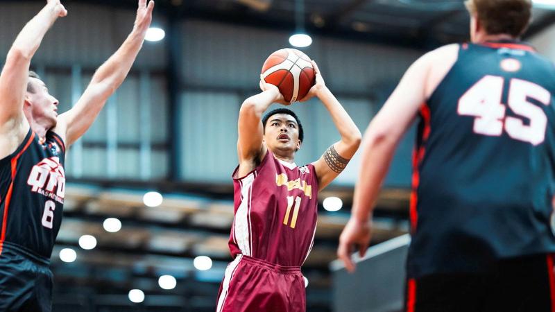 A basketballer jumps to shoot a shot during a game.