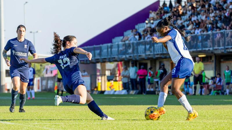 Two women play football.
