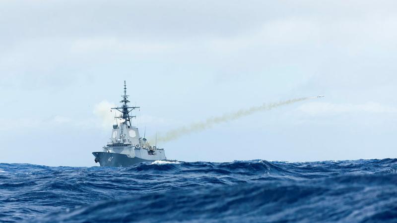 A missile fires from a ship at sea.