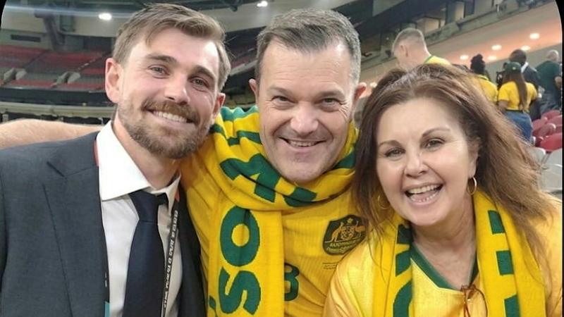Three people smile for a photo.