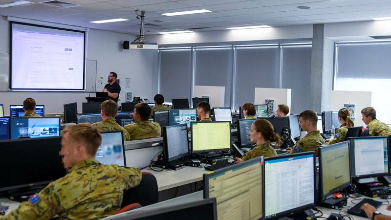 Military personnel sitting at desks.