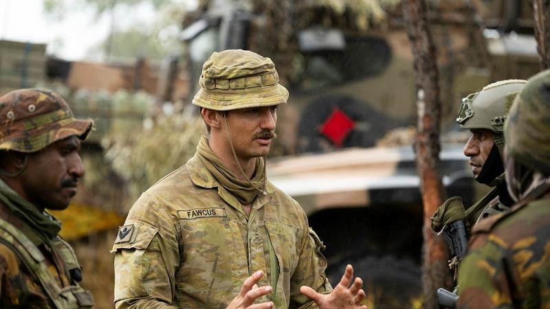 Australian Army soldier Private Harrison Fawcus from the 3rd Battalion, The Royal Australian Regiment, talks to Papua New Guinea Defence Force soldiers during Exercise Southern Jackaroo at Townsville Field Training Area, Queensland.