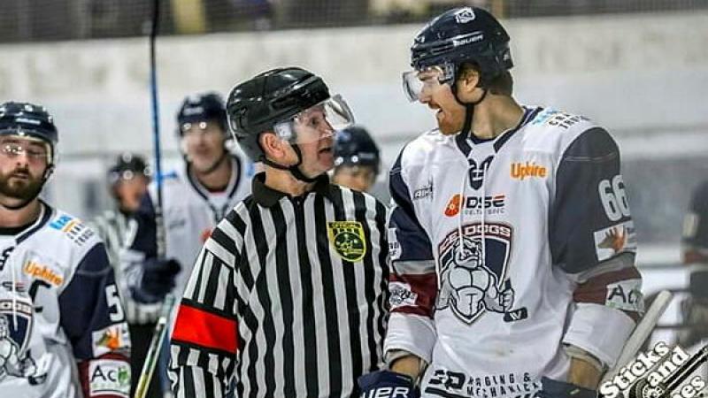 A referee talks to a player during an ice hockey game.