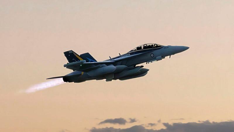 An aircraft flies in a setting sky.