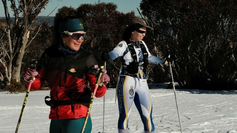 Two women in skis in the snow.