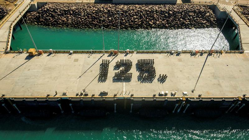 People form the number 125 on a wharf.