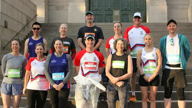 A group of people standing on stairs and wore running tags.