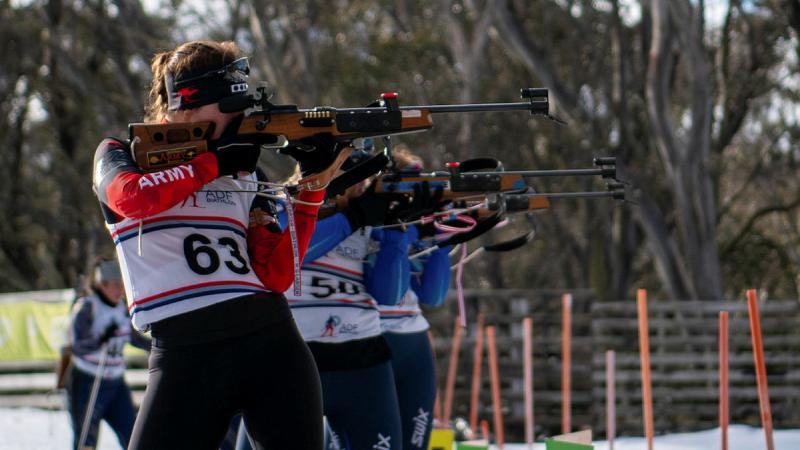 A group of military skiers shoot at targets.