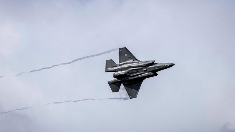 An aircraft flies in a cloudy sky.