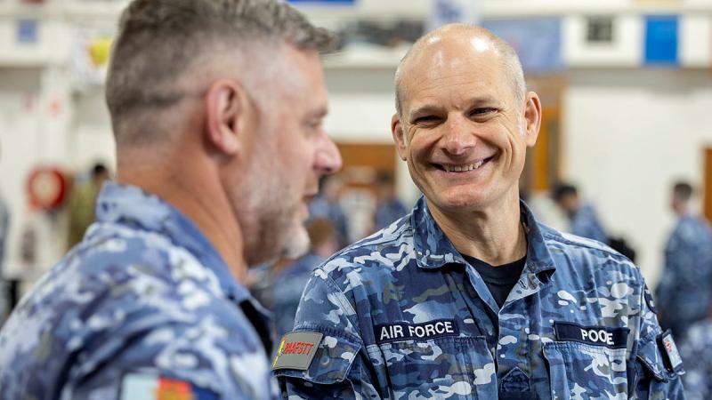 Two military men chat together.