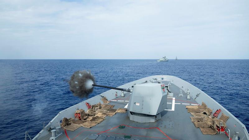The bow of a Sydney Navy war ship blasts its five - inch gun during a training exercise.