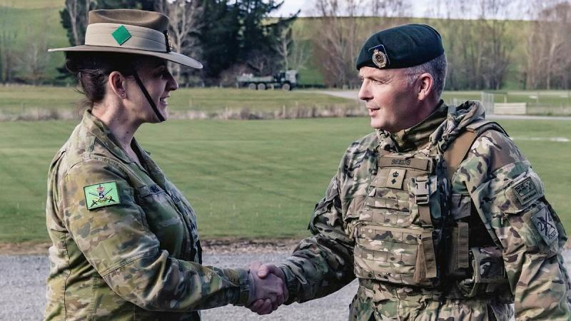 Two military personnel shake hands.