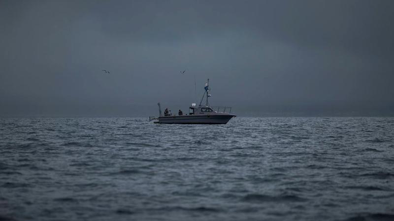 A small boat at sea on a stormy day.