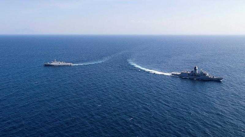 Two ships sail in opposite directions in the ocean.