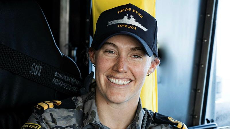 A woman in Navy uniform smiles.