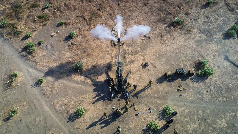 Aerial view of a large Army gun being fired.