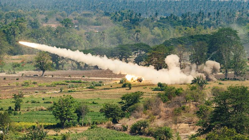 A missile shooting through the air leaving a plume of smoke behind it.