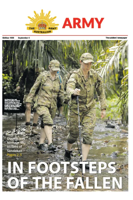 Soldiers wade through a shallow jungle creek during a commemorative trek. Headline: “In Footsteps of the Fallen.”