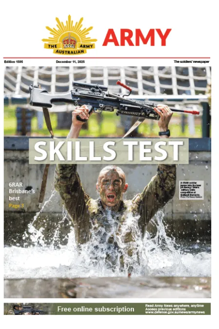 A soldier emerges from a water obstacle while holding a rifle overhead during a military skills test.