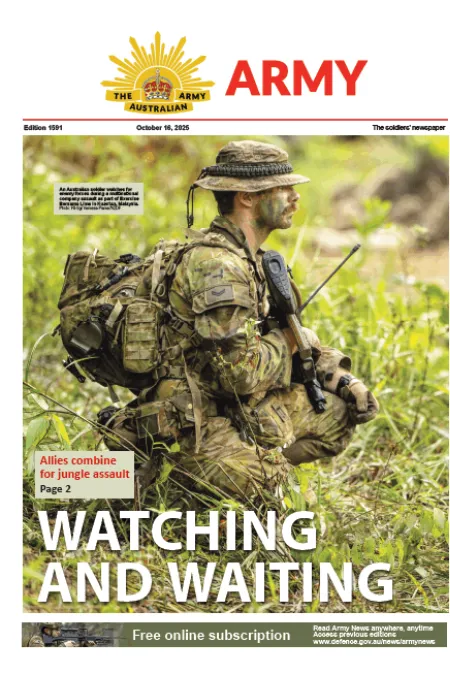 Soldier in camouflage sits in tall grass holding a rifle during a jungle training exercise. Headline: “Watching and Waiting.”