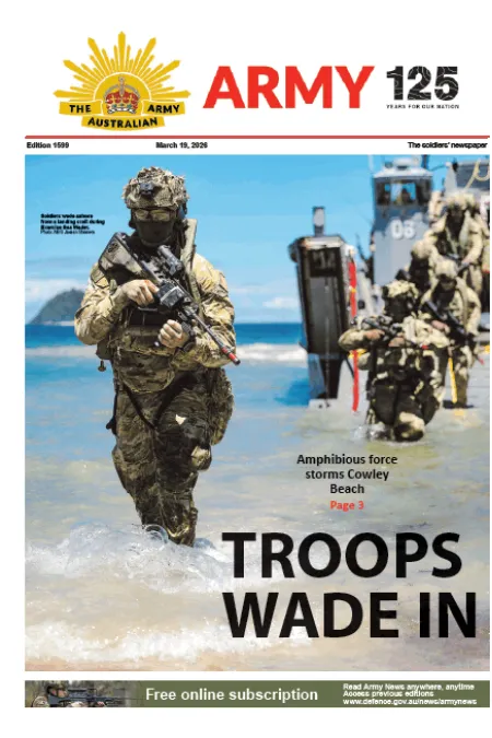 Military personnel wade ashore from a landing craft during an amphibious operation at Cowley Beach.