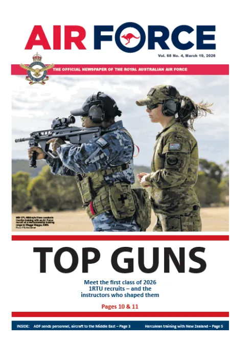 Air Force newspaper cover showing two military personnel during firearms training, with the headline “TOP GUNS.”
