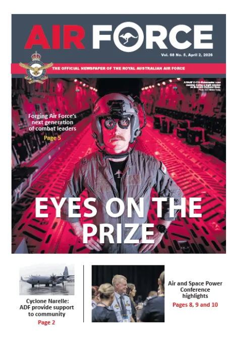 Air Force newspaper cover showing an aircrew member inside a military aircraft illuminated by red lighting, with the headline “EYES ON THE PRIZE.”