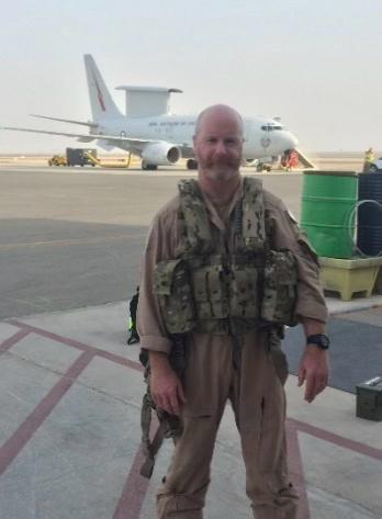 A blurry photo of a military man in front of an aircraft on the runway.