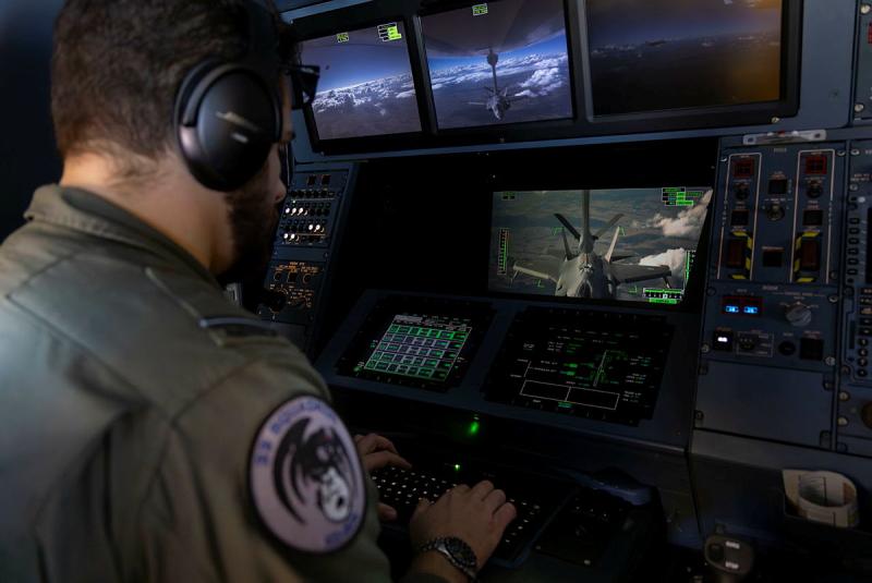 An aviator working on multiple screens while inside an aircraft.
