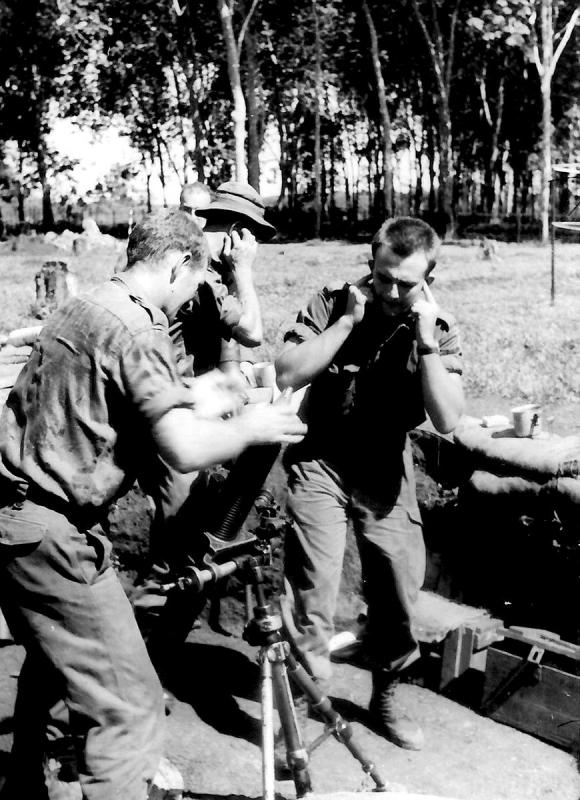A black and white historical photo of military personnel about to shoot a weapon.