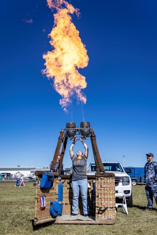 A member of the public tests the burners of the Royal Australian Air Force Balloon at the Canberra Airport Open Day 2026.