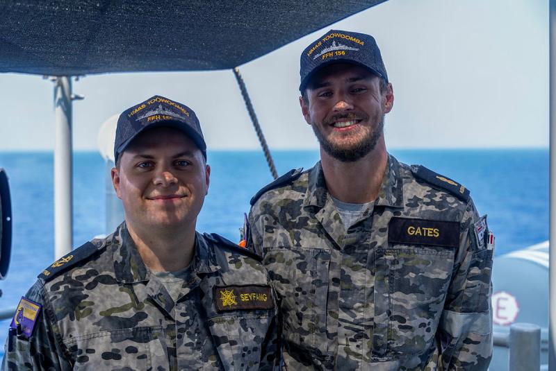 Two men in Navy uniform standing next to each other, smiling at the camera.