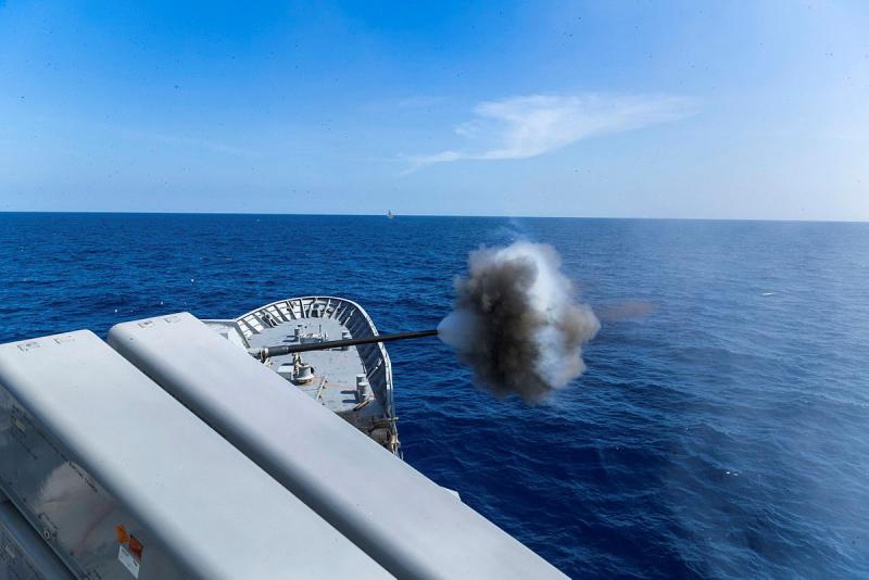 A gun fires from a ship.