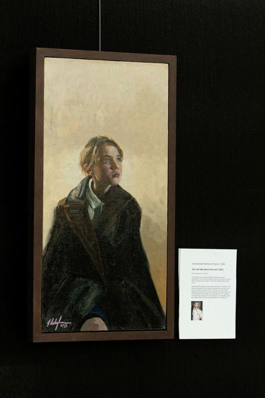 An oil painting of a young girl hangs on a wall.