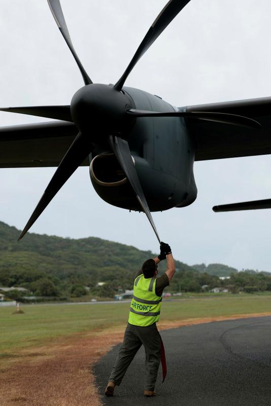 An Air Force member works on an aircraft's propeller.