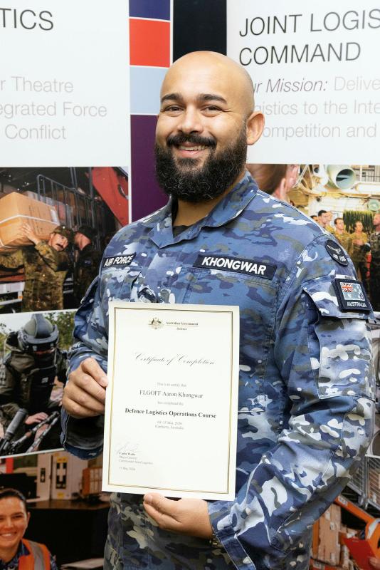 Royal Australian Air Force Flying Officer Aaron Khongwar with a certificate for completion of the Defence Logistics Operations Course at HMAS Harman, Canberra. 