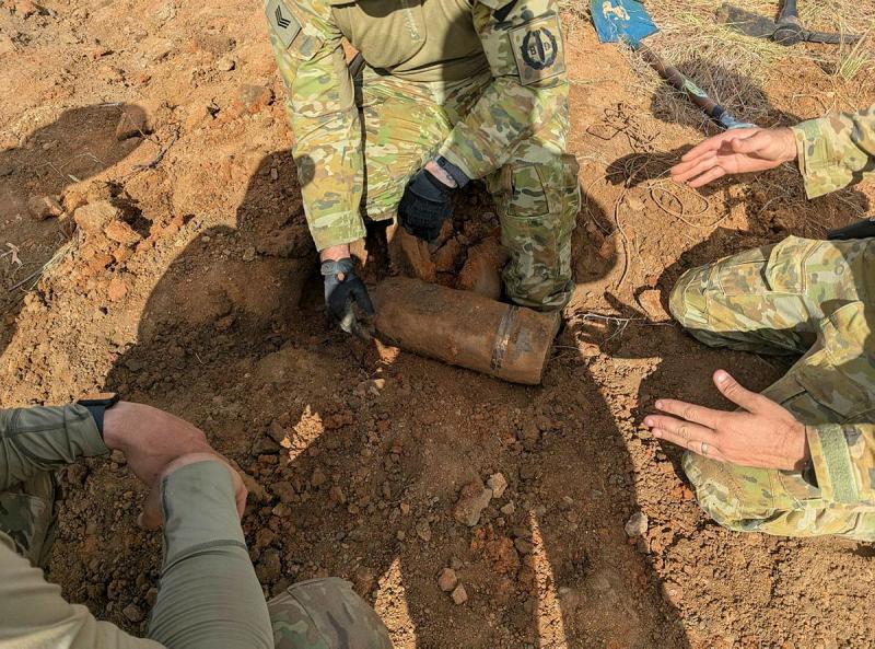 Military personnel discover a buried unexploded bomb.