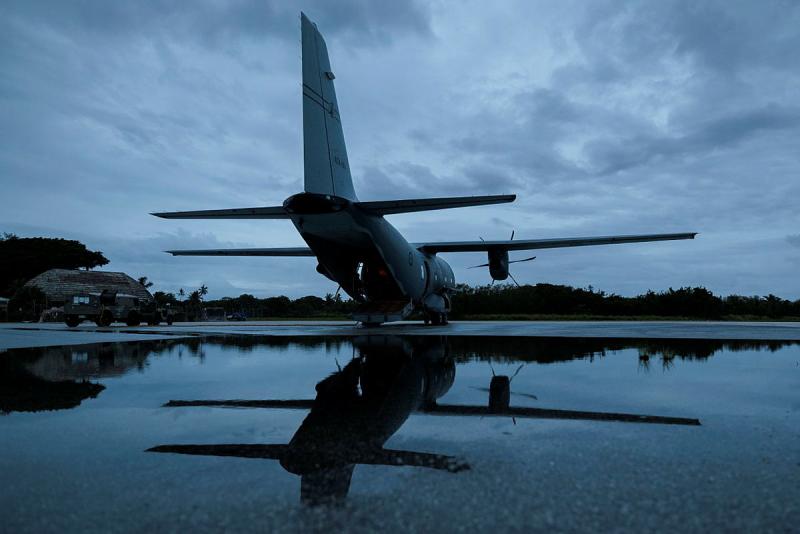 A stationary aircraft on the tarmac on a cloudy day.